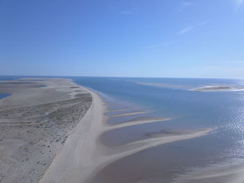 Scenic view of beach against clear blue sky