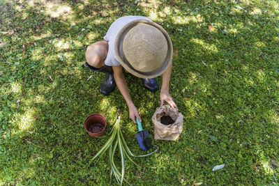 High angle view of person holding hat on grass