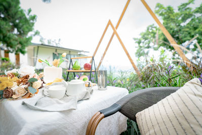 Coffee cup and flowers bouquet on table in garden. afternoon tea concept. home outdoor furniture.