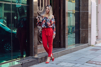 Full length portrait of woman standing at store