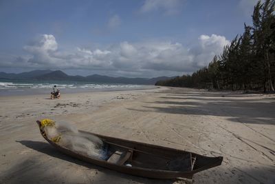 Fishing boat moored at padang melang beach against sky