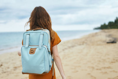 Rear view of woman standing on beach