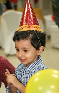 High angle view of cute boy wearing party hat during birthday