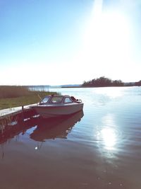 Boats moored on lake against sky