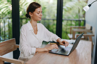 Young woman using laptop at table