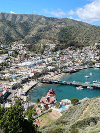 High angle view of townscape by sea against mountain