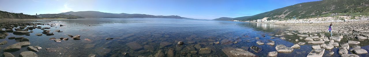 water, mountain, scenics, tranquil scene, tranquility, beauty in nature, mountain range, blue, nature, sky, lake, sunlight, idyllic, clear sky, sea, day, rock - object, non-urban scene, outdoors, panoramic