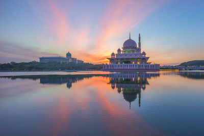 Putra mosque by lake against sky during sunrise