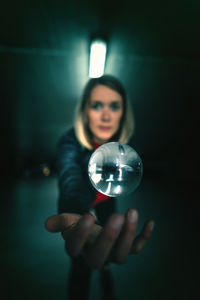 Portrait of young woman holding crystal ball