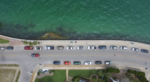 Aerial view of cars on road by sea 