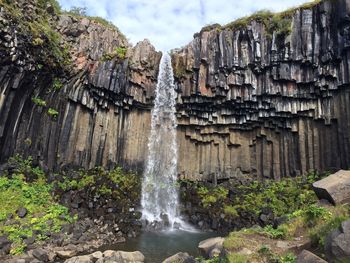 Scenic view of waterfall against sky