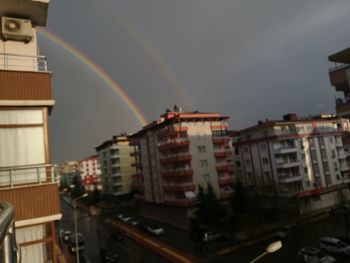 Rainbow over buildings in city