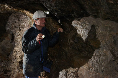 Man wearing helmet standing in cave