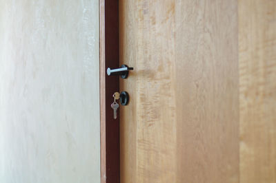 Selective focus on modern style of knob on wooden door with keys hanging on lock