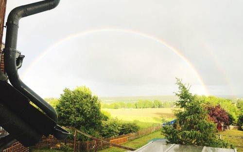 Scenic view of rainbow over landscape against sky