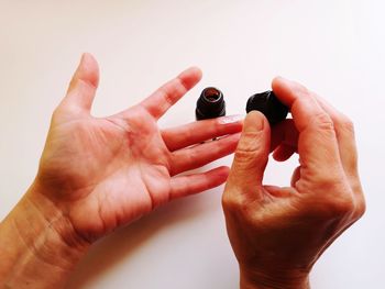 Close-up of hands holding camera over white background