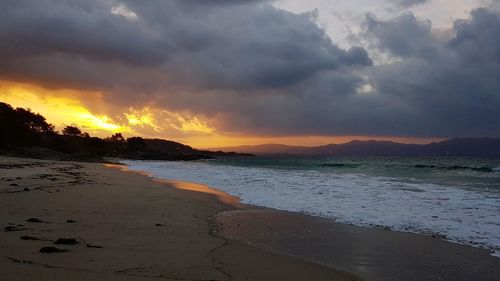 Scenic view of beach against sky during sunset