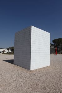 White built structure on field against clear blue sky