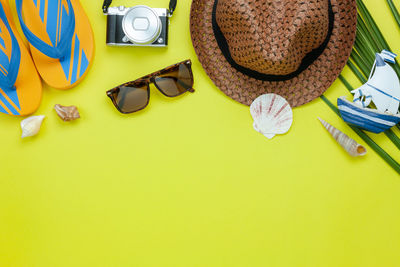 High angle view of beach supplies over yellow background