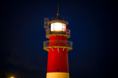 Low angle view of illuminated lighthouse against sky at night in büsum 