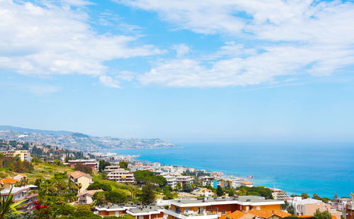 High angle view of townscape by sea against sky