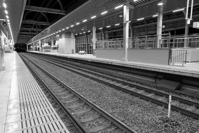 Train at railroad station platform at night