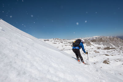 People on snowcapped mountain against sky