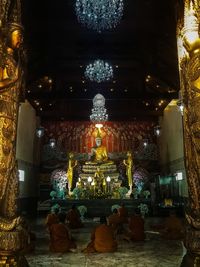 Statue against illuminated temple at night