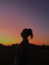 Silhouette man standing on field against sky during sunset