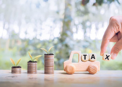 Midsection of woman holding coins on table