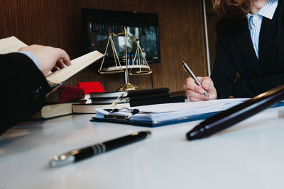 Cropped image of people with hands on table