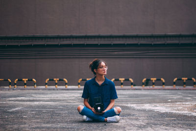 Young woman sitting on bridge