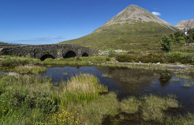 Arch bridge over lake against sky