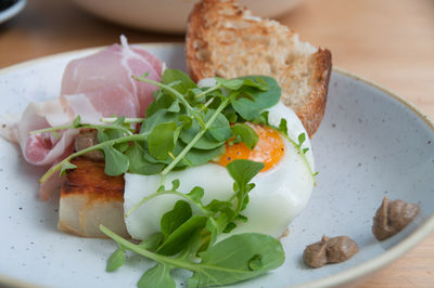 Breakfast of egg with runny yolk on sourdough toast with bacon, pancetta. breakfast meal close up