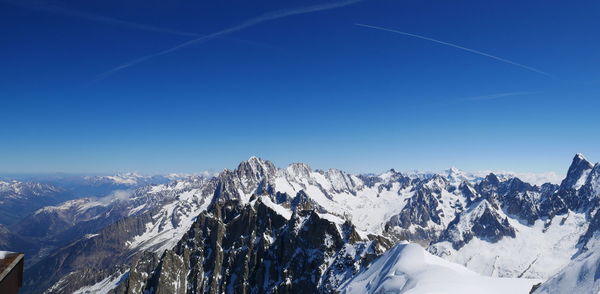 Scenic view of snowcapped mountains against clear blue sky