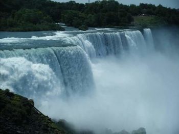 Scenic view of waterfall against sky