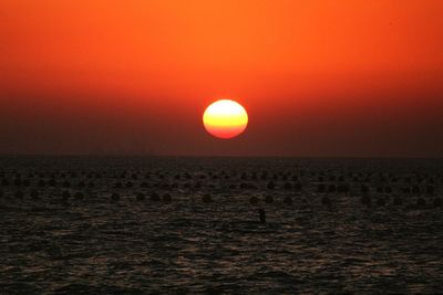Scenic view of sea against orange sky