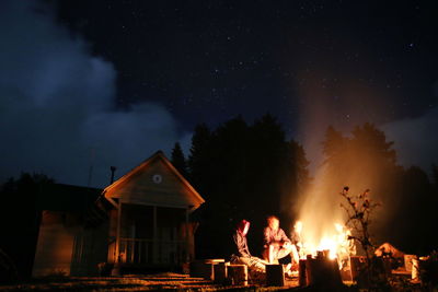 Silhouette of fire against sky at night