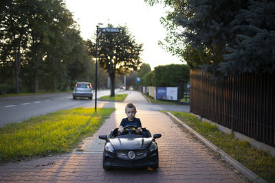 Portrait of boy driving toy car