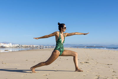 Yoga woman doing yoga pose on the beach for wellbeing health lifestyle.