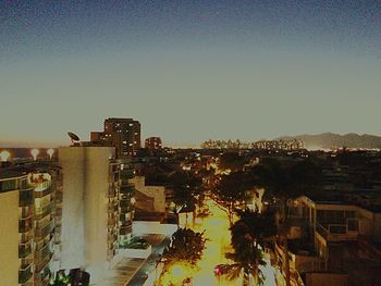 Illuminated cityscape against clear sky