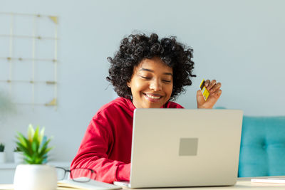 Portrait of young woman using laptop at home