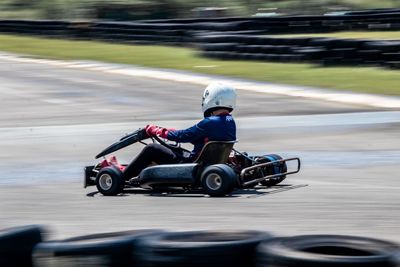 Man riding go kart on racing circuit 