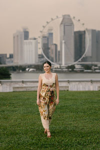 Portrait of woman standing on grassy field