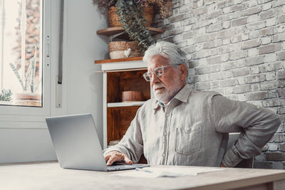 Rear view of woman using laptop on table
