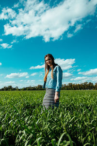 Full length of young woman standing in farm