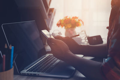 Midsection of woman using mobile phone