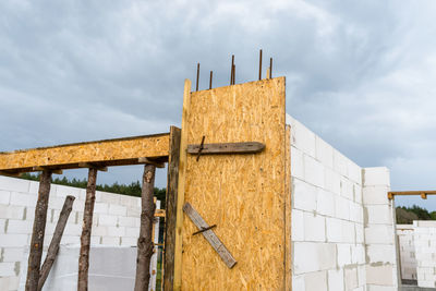 The walls of a house built of white brick with reinforced concrete pillars at the end of which