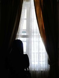 Close-up of woman standing against white wall