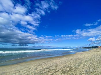 Scenic view of beach against blue sky